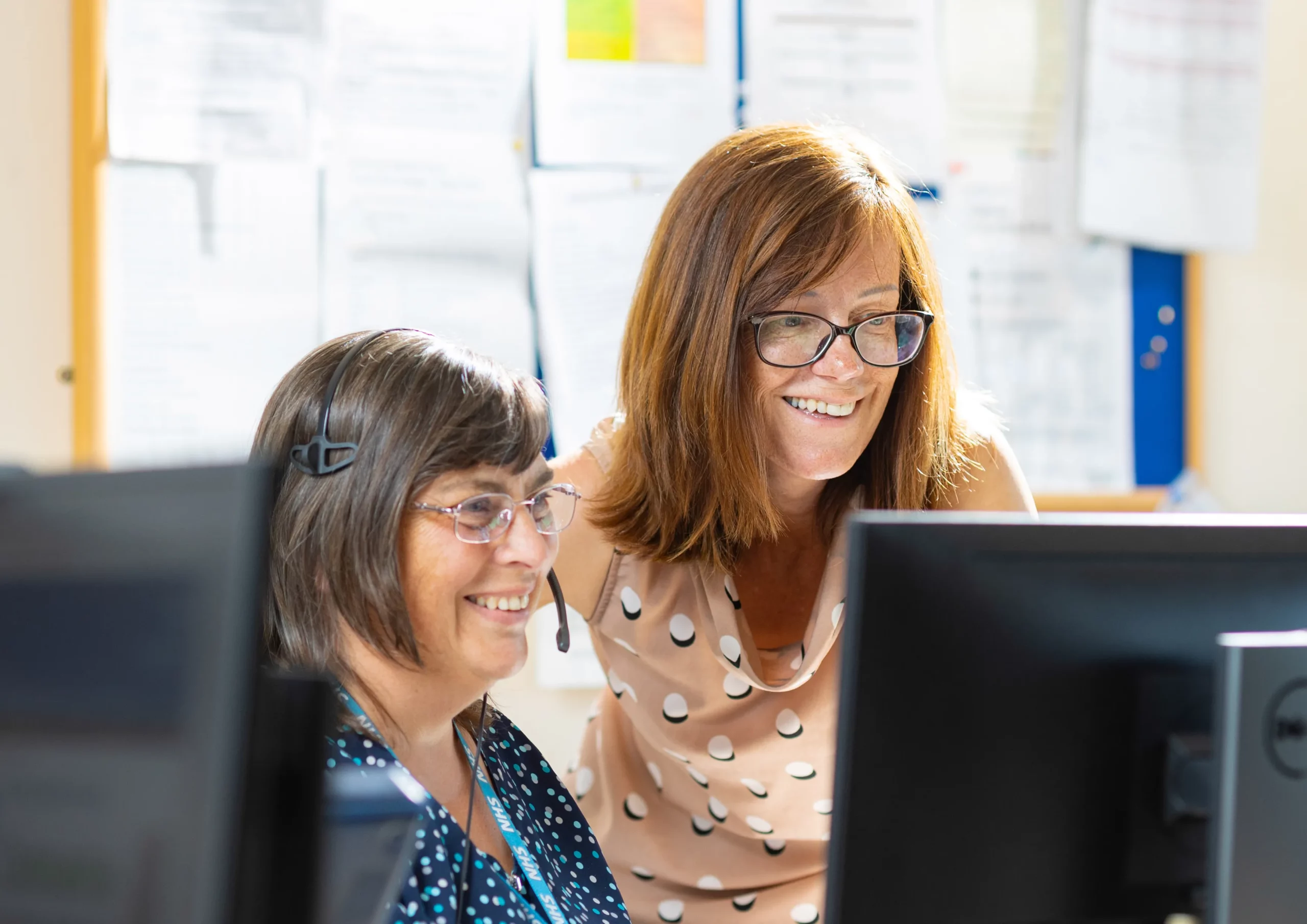 NHS Kent & Medway - 2 women with glasses on smiling at monitor