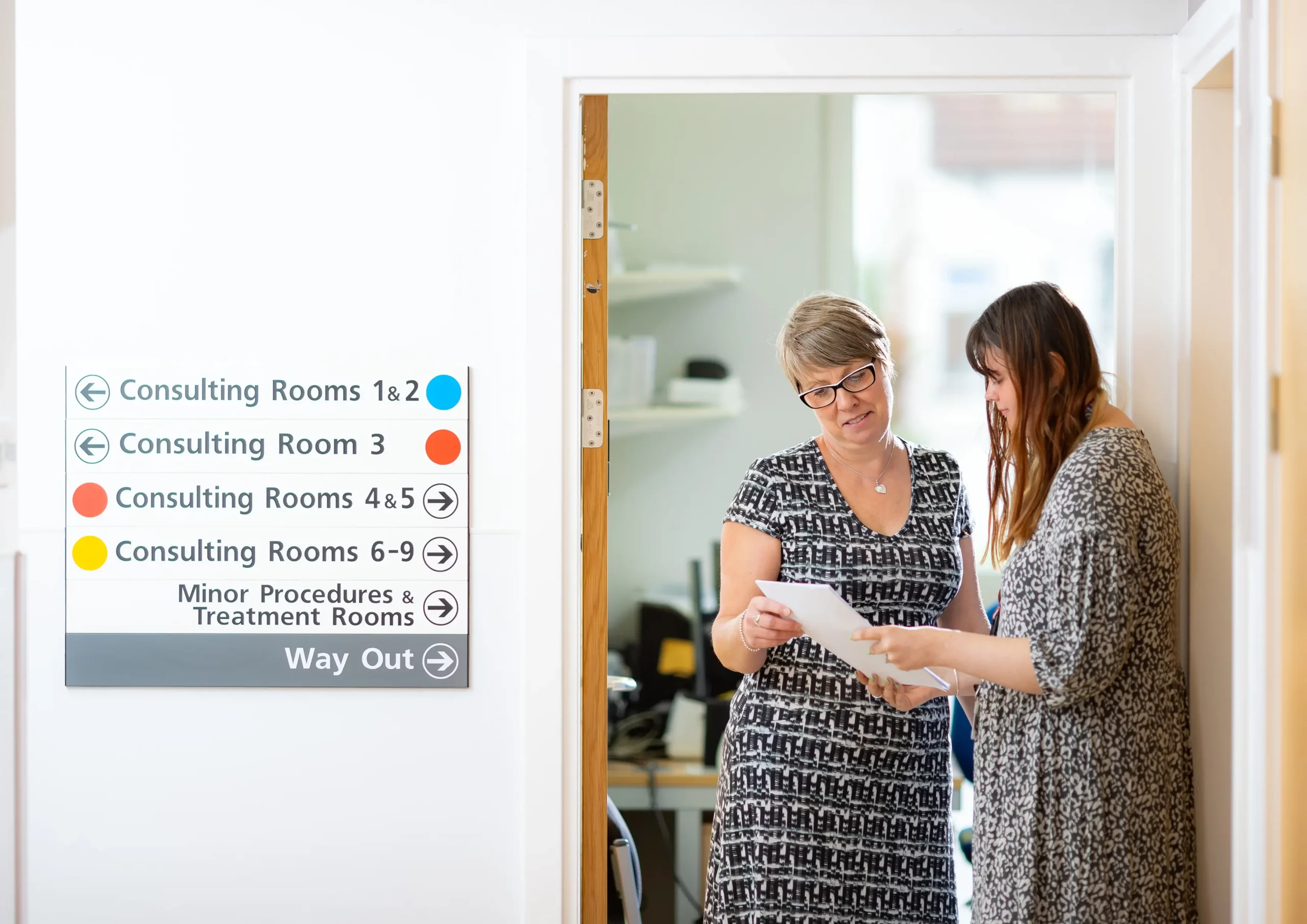 NHS Kent & Medway - 2 women looking at a sheet of paper